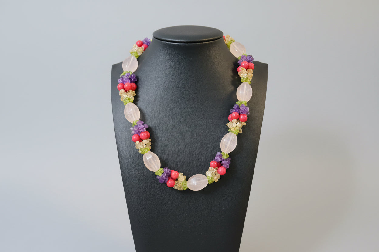 Colorful beaded necklace on a gray surface with a wooden background